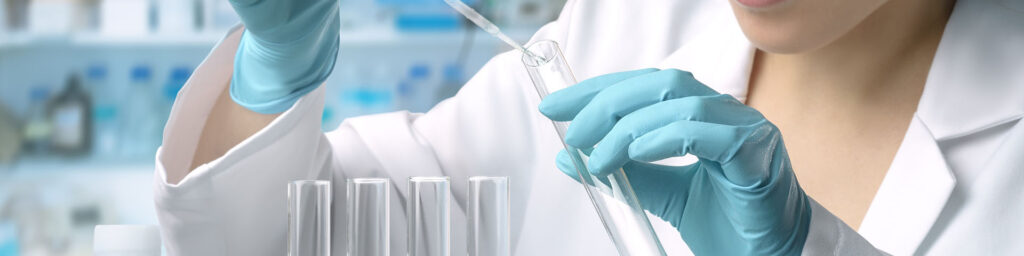 A photo of a person in a lab coat holding a test tube