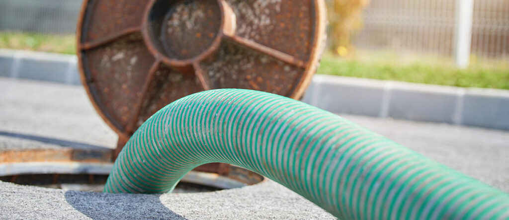 A photo of a large hose going into a manhole